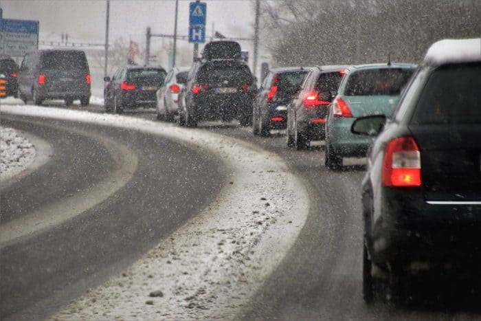A long line of cars driving in snow.