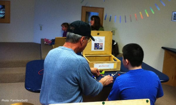 dad and son working on a project at the ithaca sciencenter. 