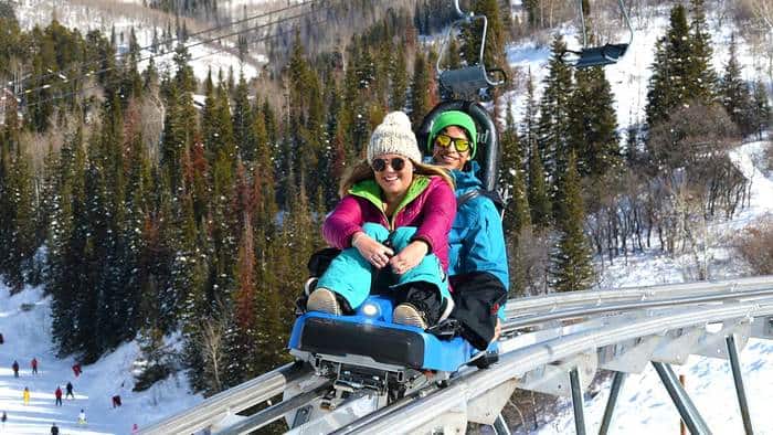 A couple rides the outlaw mountain coaster at steamboat resort in winter.