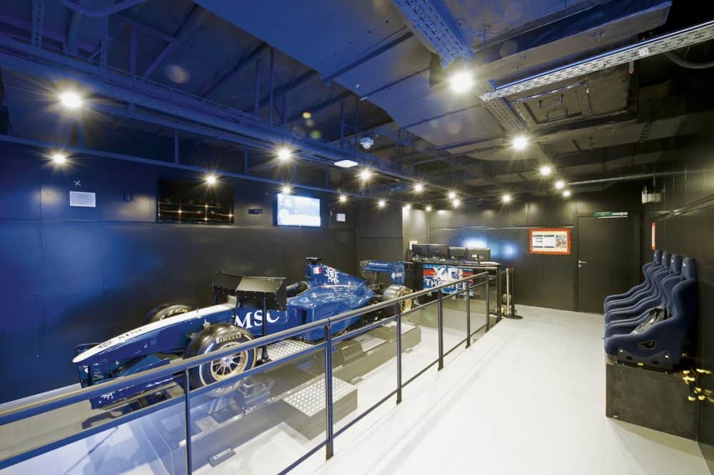 The sleek and high tech formula one racing simulator on the msc divina sits inside a small race car.