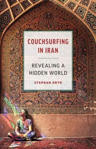 30 Books To Inspire Your Next Vacation the author of couhsurfing in iran sitting in front of an elaborate persiab mural.