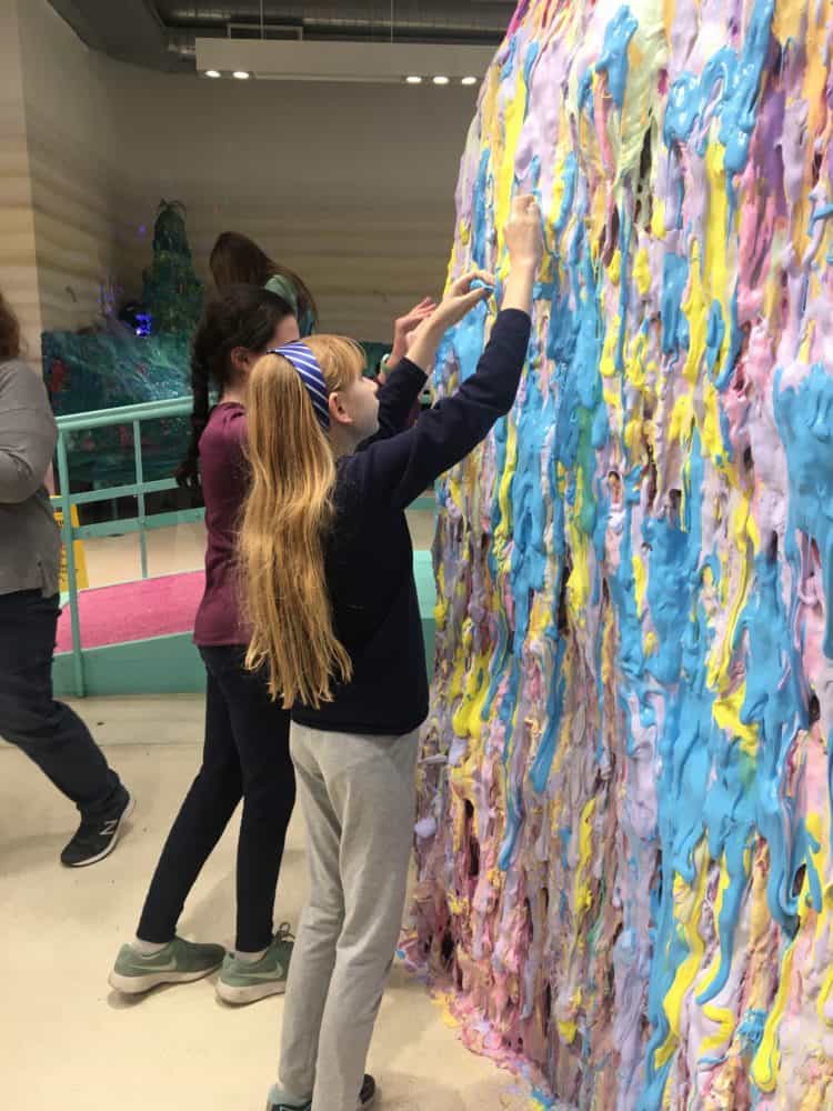 Adding to the slime wall at the nyc slime museum