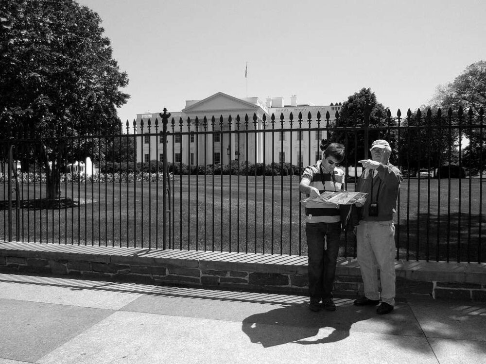 Tourists looking at a map outside the white house.
