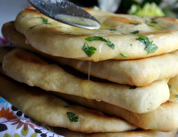 a stack of fresh garlic naan with parsley