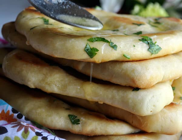 A stack of fresh garlic naan with parsley