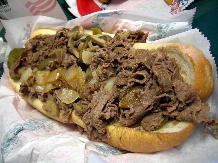 A philly cheesesteak with pepers and onions.