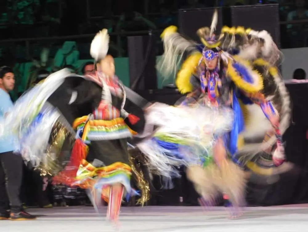 two dancers in action at the gathering of nations.