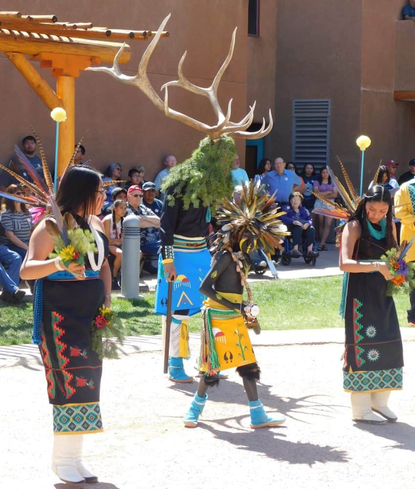 a native american high school dance troupe performs at the pueblo cultural center.