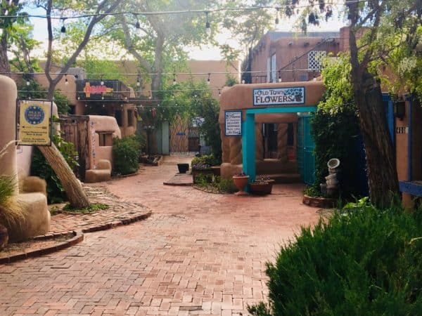 the quirky courtyard outside of the chapel of our lady of guadalupe in old town albuquerque