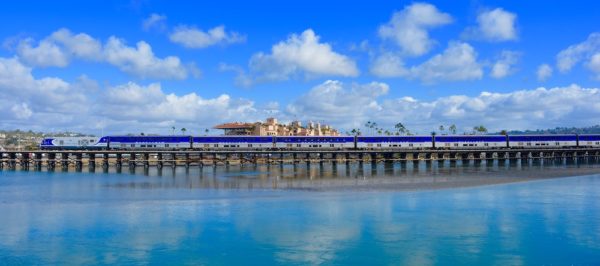 The amtrak pacificliner takes a scenic route up the southern california coast. Here it has ocean on one side and art deco buildings on the other.