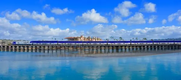 the amtrak pacificliner takes a scenic route up the southern california coast. here it has ocean on one side and art deco buildings on the other. 