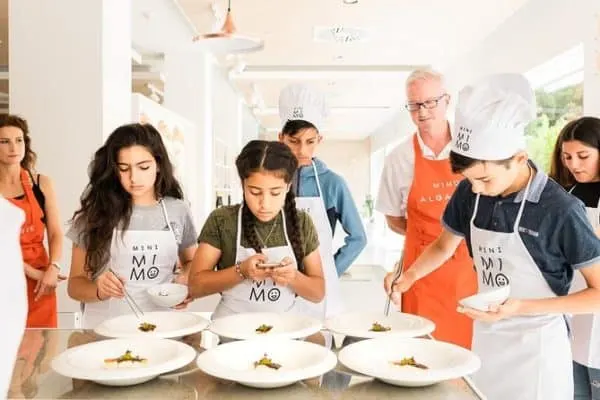 teens ande parents cook together at a class in the algarve.