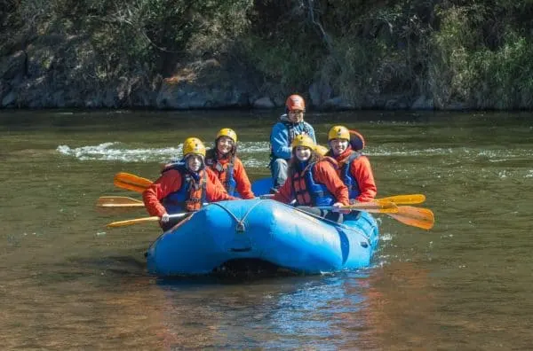 Here's How To Plan A Memorable Vacation With Your Teen a family rafting on a calm river together