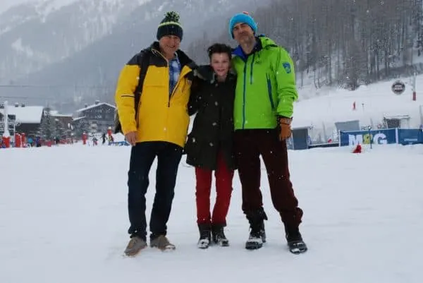 Here's How To Plan A Memorable Vacation With Your Teen a teen on a ski vacation with her dads.