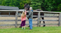 cooperstown weekend: 7 unexpected things to do with kids: here a father and daughter pet a horse at the farmers' museum.