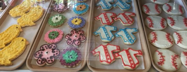 Sugar cookies look like yellow chicks, spring flowers, baseballs and baseball jerseys in the window at schneider's bakery in cooperstown.