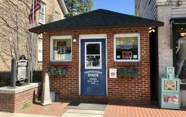 The front door of the tiny, red-brick cooperstown diner beckons with the promise of burgers and shakes.