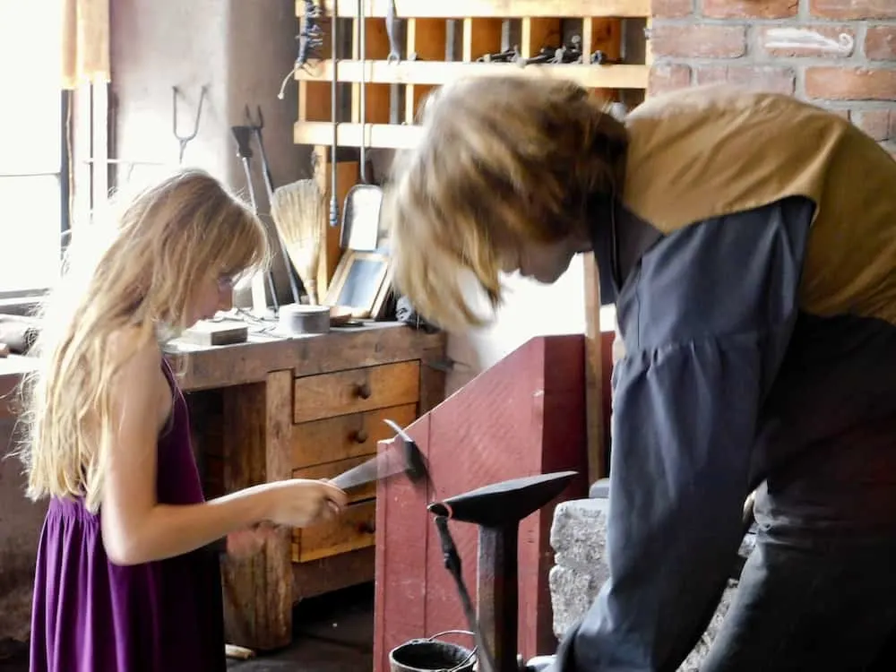 Cooperstown, Ny: Way More Than Baseball For A Family Getaway A blacksmith and a girl work on an iron project at the farmers' museum