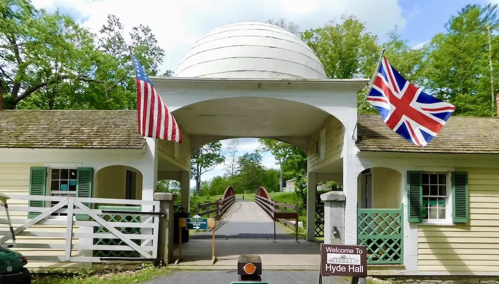 the onion-domed gate house and bridge leading to hyde house in glimmerglass state park. 