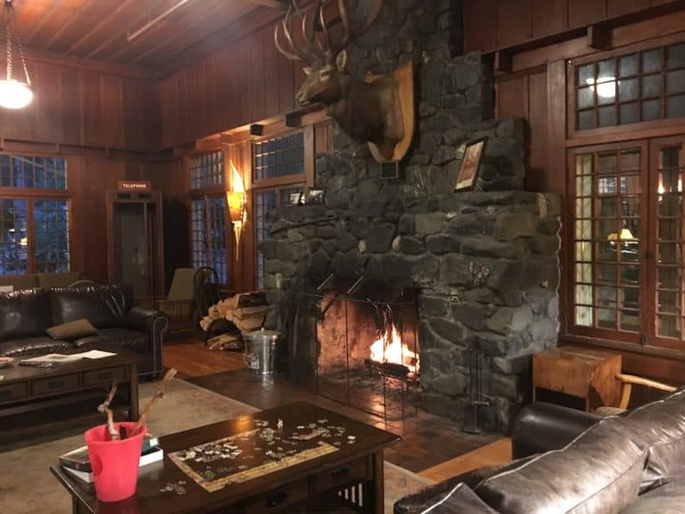 a buck hangs over the fireplace in the woodsy main room of lake crescent national park lodge in olympic.