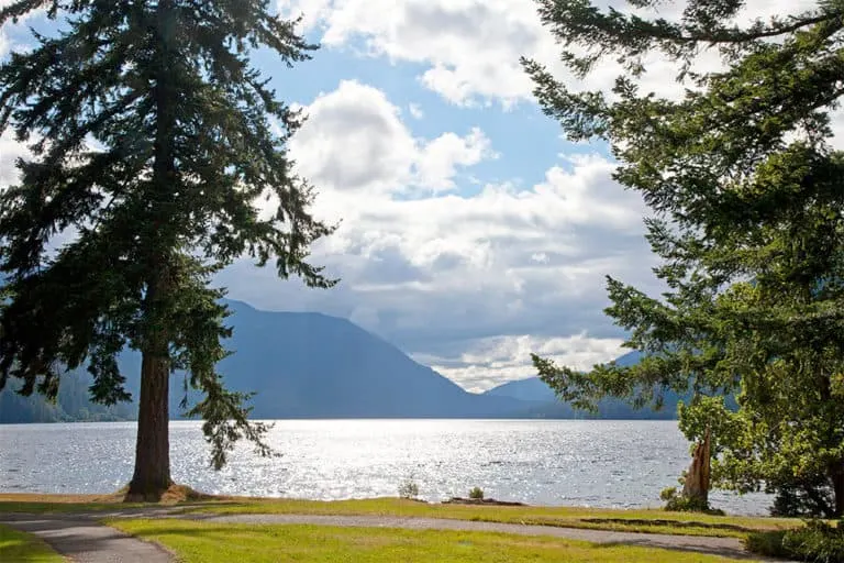 lawn, pine trees, lake, mountains and sky. the view of crescent lake lodge in washington.