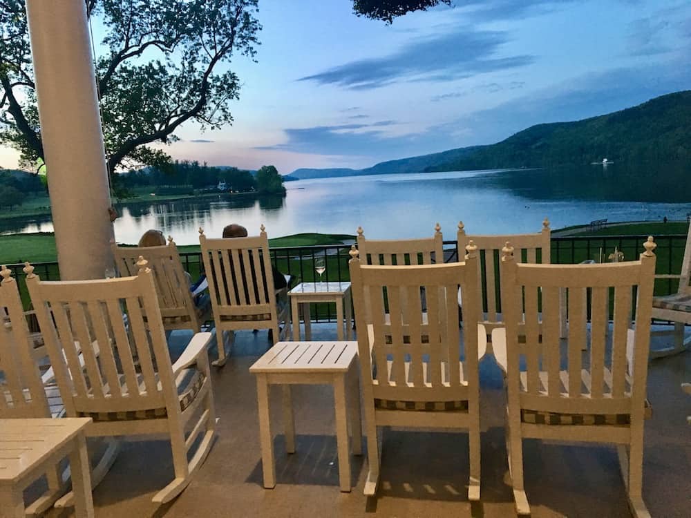the view of otesaga lake at sunset from the rocking chairs on the porch of the otesaga resort.
