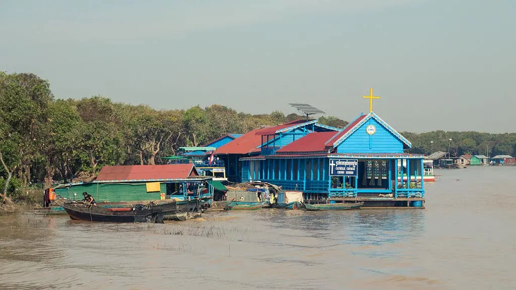 a floating church and other buildings in a floating village on tonle sap in cambodia.