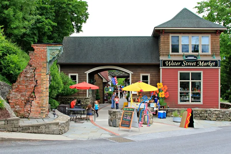 the patio fpr waterstreet market with outdoor tables, vendors, street art and and an arched entrance.