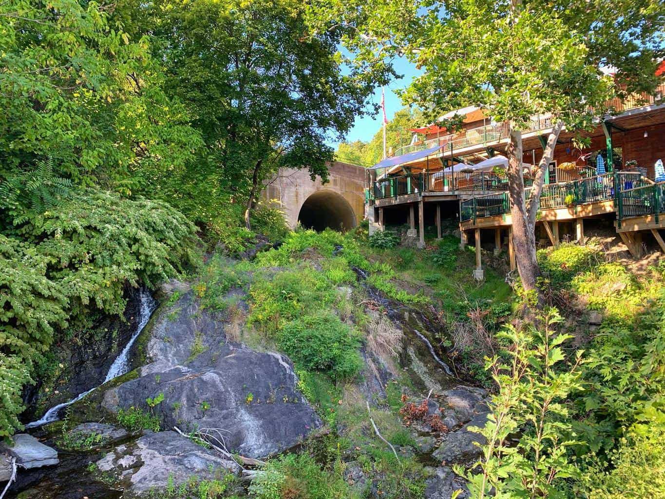 the falcon music venue in upstate, ny has terrace overlooking a waterfall and lots of greenery.