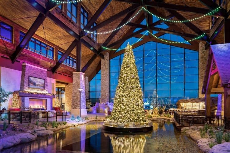 gaylord's rockies resort decorates its atrium for christmas with a giant fireplace, lights, trees and fake snow inside, and real snow outside its giant windows