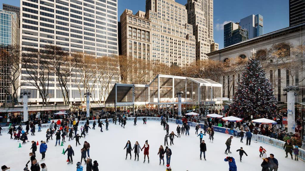 the ice skating rink and winter village shops in bryant park, next to the ny public library.