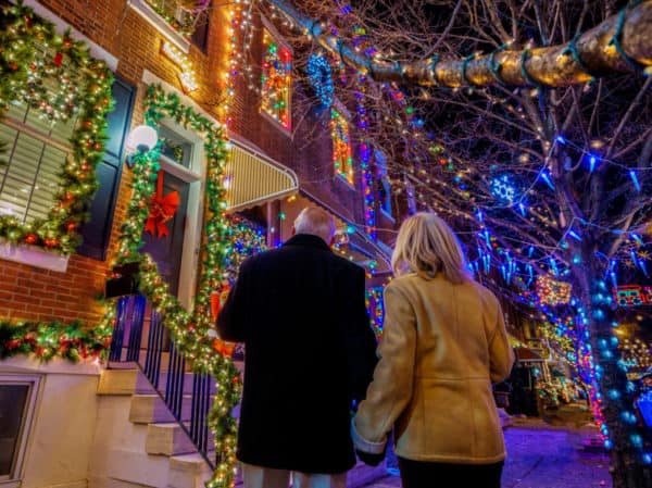 A couple admires the over-the-top lights on people's rowhouses on 13th street in south philly.