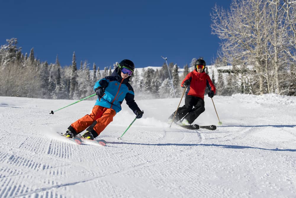 A father and a son skiing the wide beginner trails in park city, utah
