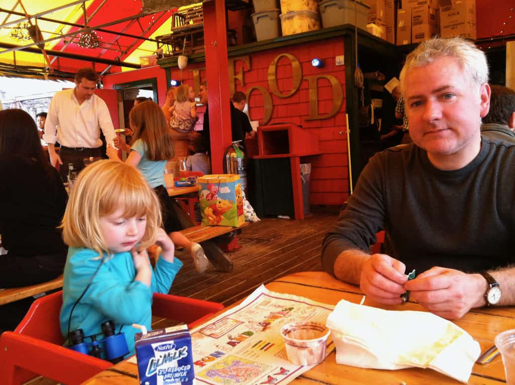 a lucky dad and daughter at an outside table at the barking crab in boston.