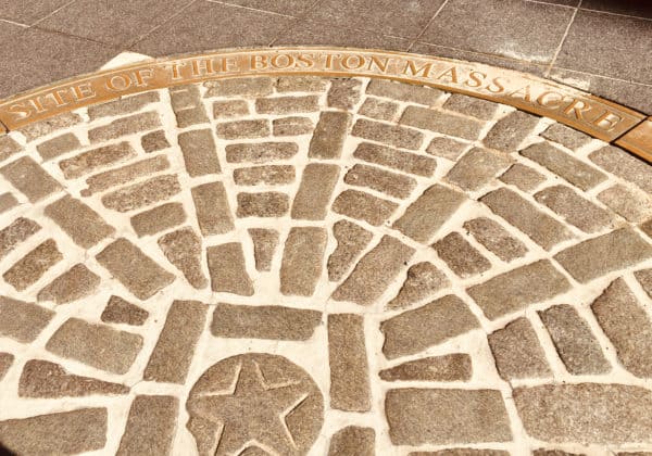 A sidewalk marker near quincy market notes the site of the boston massacre.