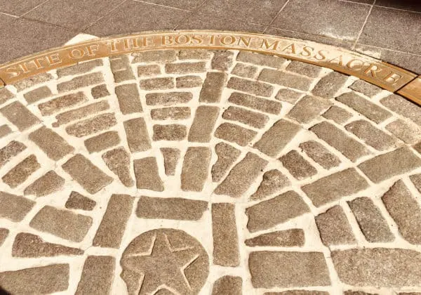 a sidewalk marker near quincy market notes the site of the boston massacre.