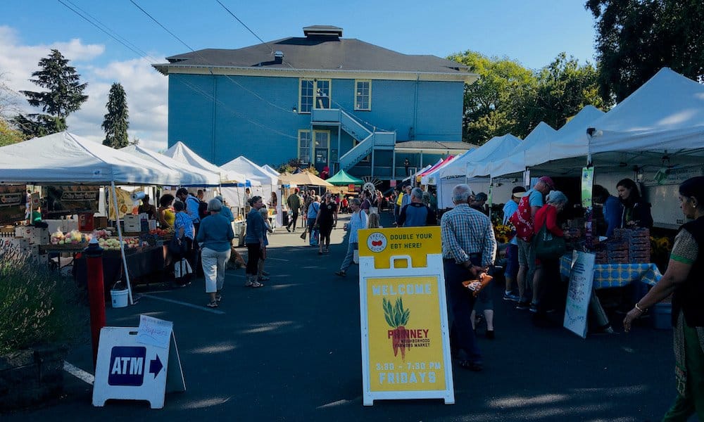 a row of stalls at the weekly afternoon farmers market in phinney ridge.