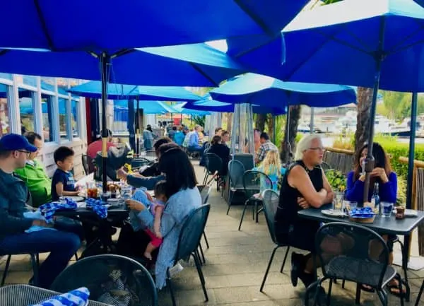 Seattle Weekend Getaway: 15 Of The Best Things To Do With Kids the lakeside patio with bright blue umbrellas at duke's seafood in seattle.