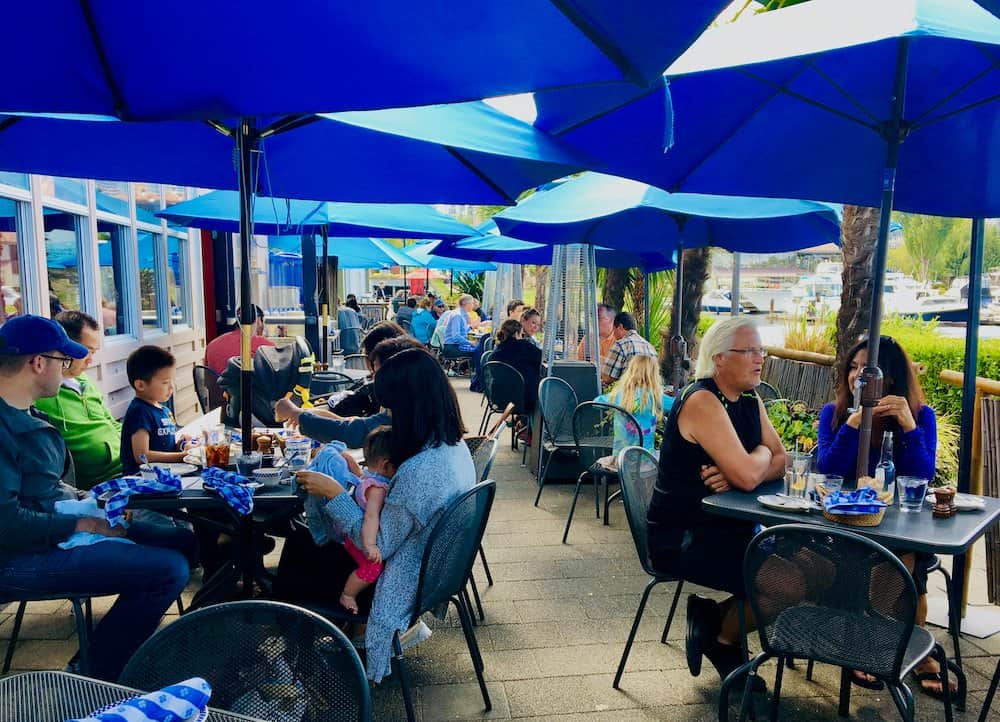 The lakeside patio with bright blue umbrellas at duke's seafood in seattle.