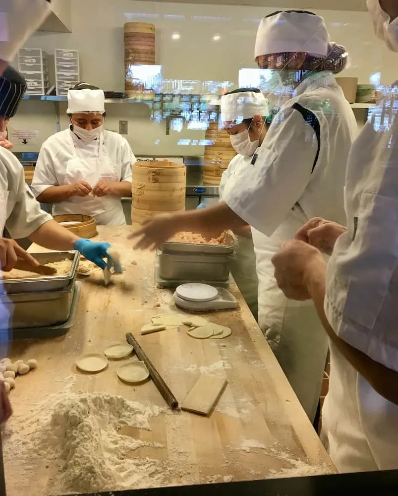 watching the cooks make dozens of dumplings at din tai fung in seattle.