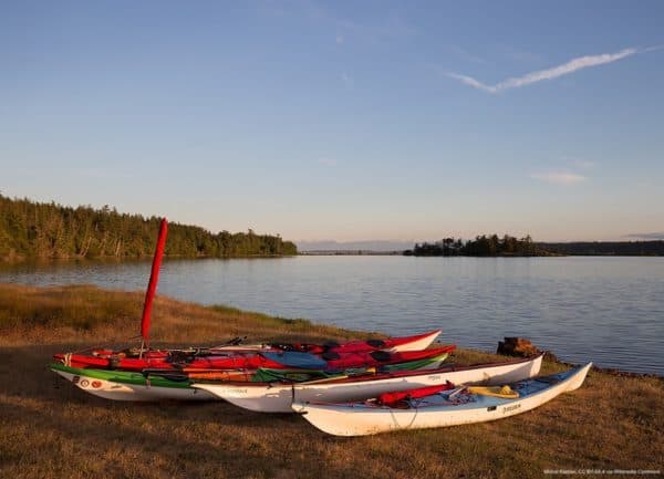 Kayaks on a grassy beach off on an island off of sidney bc