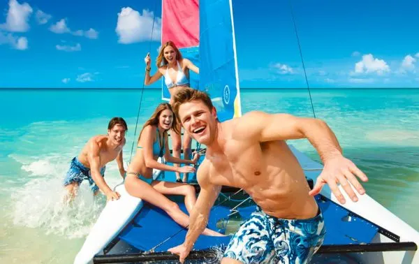 teens bonding during a trip on a small catamaran at beaches.
