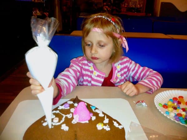 A girl decorates a giant heart cookie at gingerbread university in riverhead.