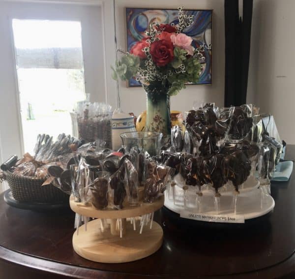 Lots of lovely easter chocolate lollipops in baskets on a table.
