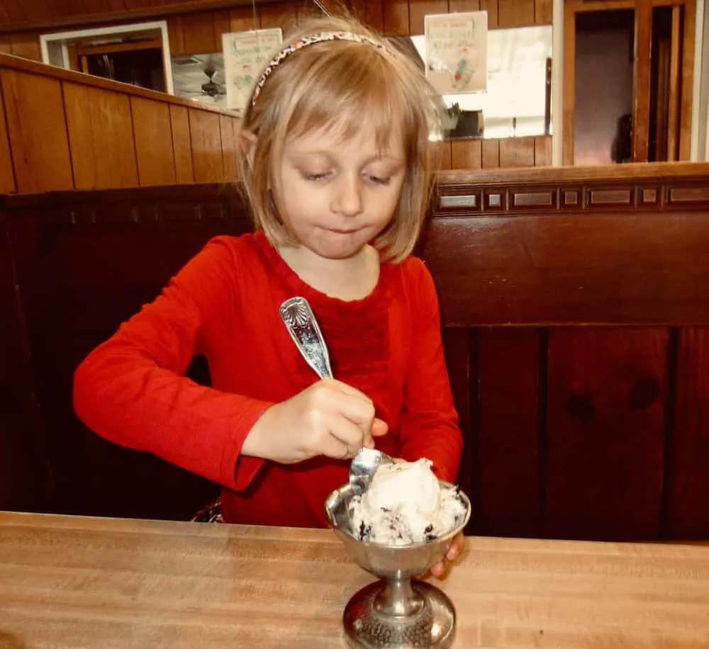 a girl eats housemade chocolate chip ice cream at sip 'n' soda in southampton, long island.