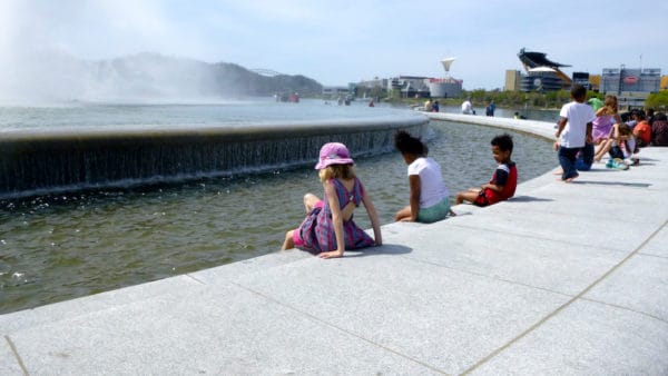 the fountain at point state park attracts kids for splashing while parents take in views that include the city's stadiums.
