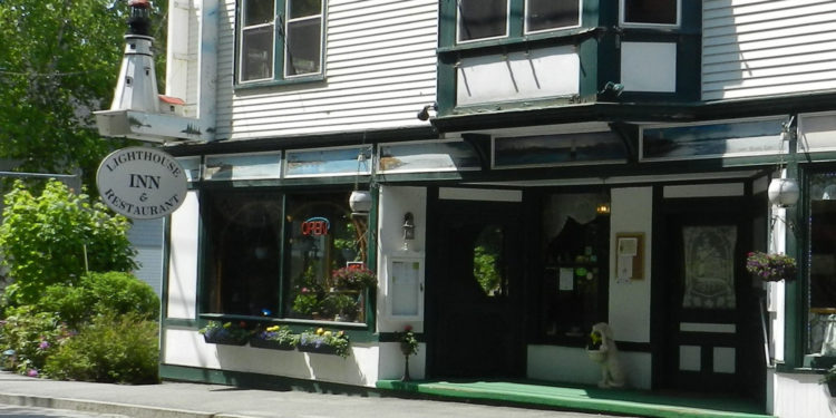 the white-washed new england exterior of the family-run lighthouse inn outside of bar harbor.