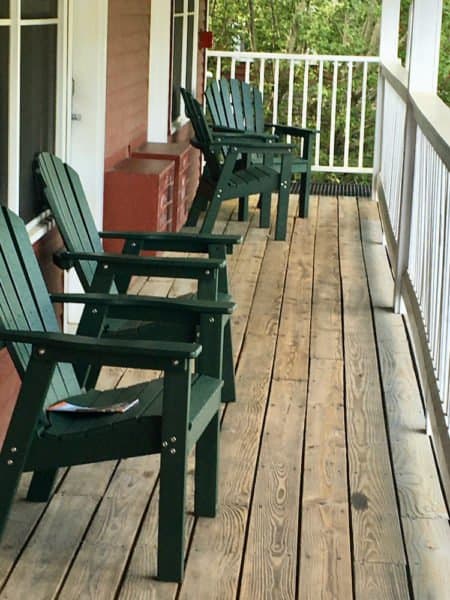 An outdoor porch with adirondack chairs in the green mountain inn annex