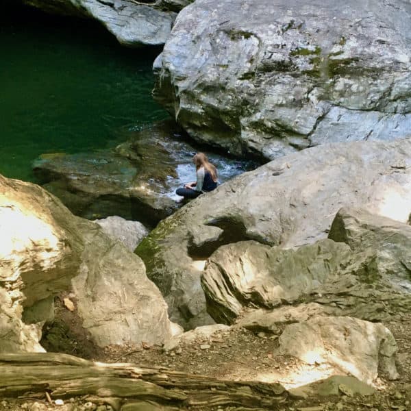 A girl climbs down to the the swimming holes below bingham falls in vermont.