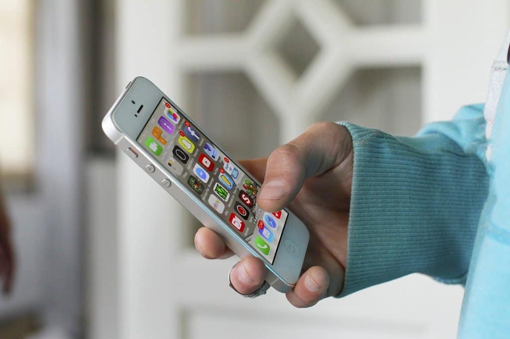 A person looks for apps on their phone to help them monitor their travel plans.